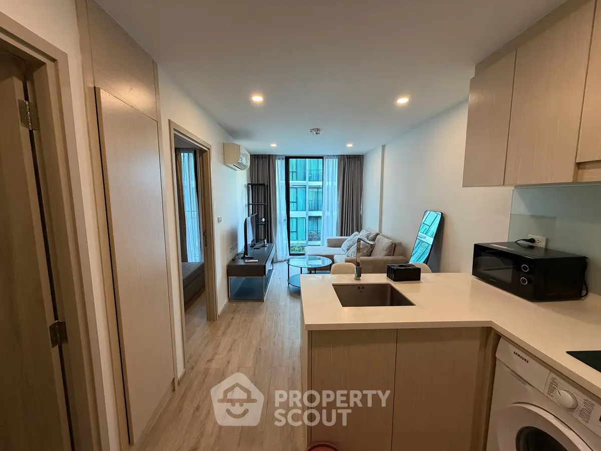 Modern open-plan apartment with cozy living area and compact kitchen