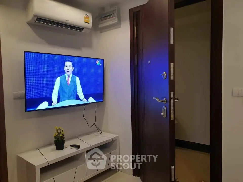 Modern interior with wall-mounted TV and air conditioning in a cozy living space.