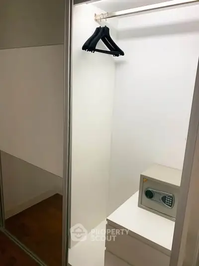 Spacious walk-in closet with secure safe and ample storage space.