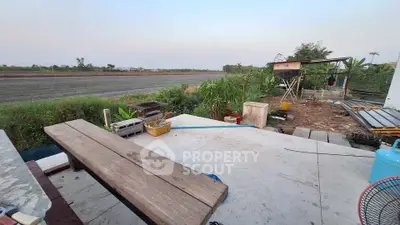 Spacious outdoor area with rustic wooden bench and scenic rural view, perfect for relaxation and outdoor activities.