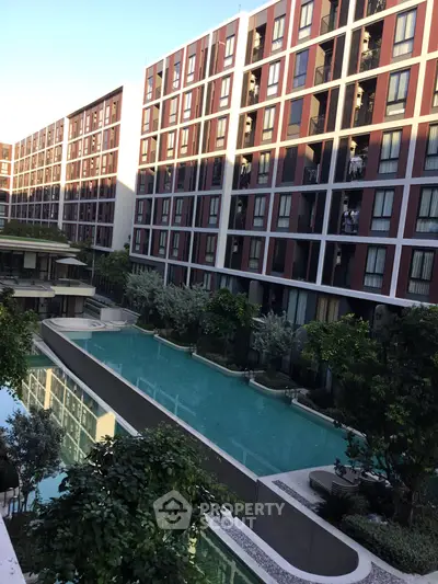 Modern apartment complex with luxurious pool and lush greenery