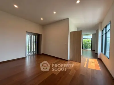 Spacious modern living room with wooden flooring and natural light