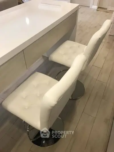 Modern kitchen with sleek white bar stools and elegant countertop