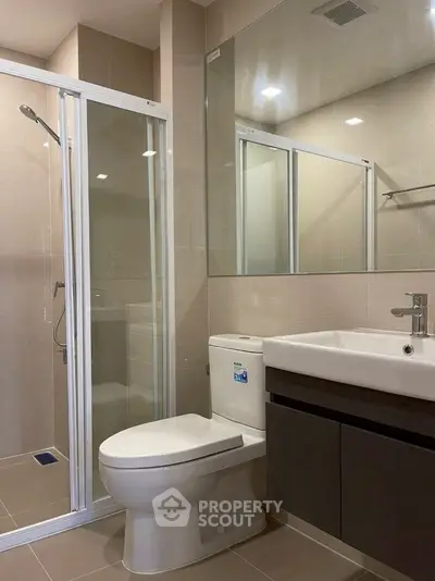 Modern bathroom with glass shower and sleek fixtures in a contemporary apartment.