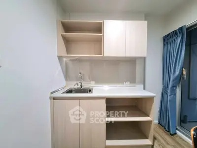 Modern compact kitchen with light wood cabinets and sleek design