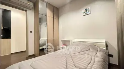 Cozy bedroom with modern decor and mirrored wardrobe in stylish apartment.