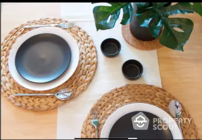 Elegant dining setup with woven placemats and modern black tableware