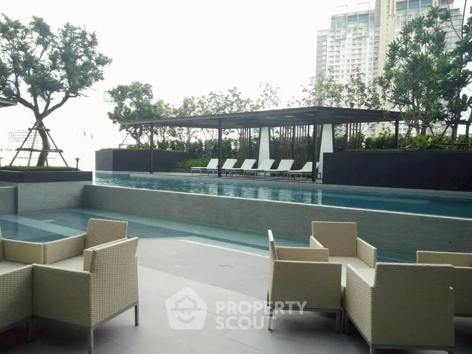 Luxurious poolside area with modern seating and skyline view, perfect for relaxation and entertainment.