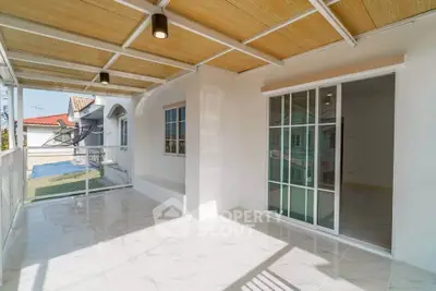 Spacious balcony with sliding glass doors and modern ceiling design.