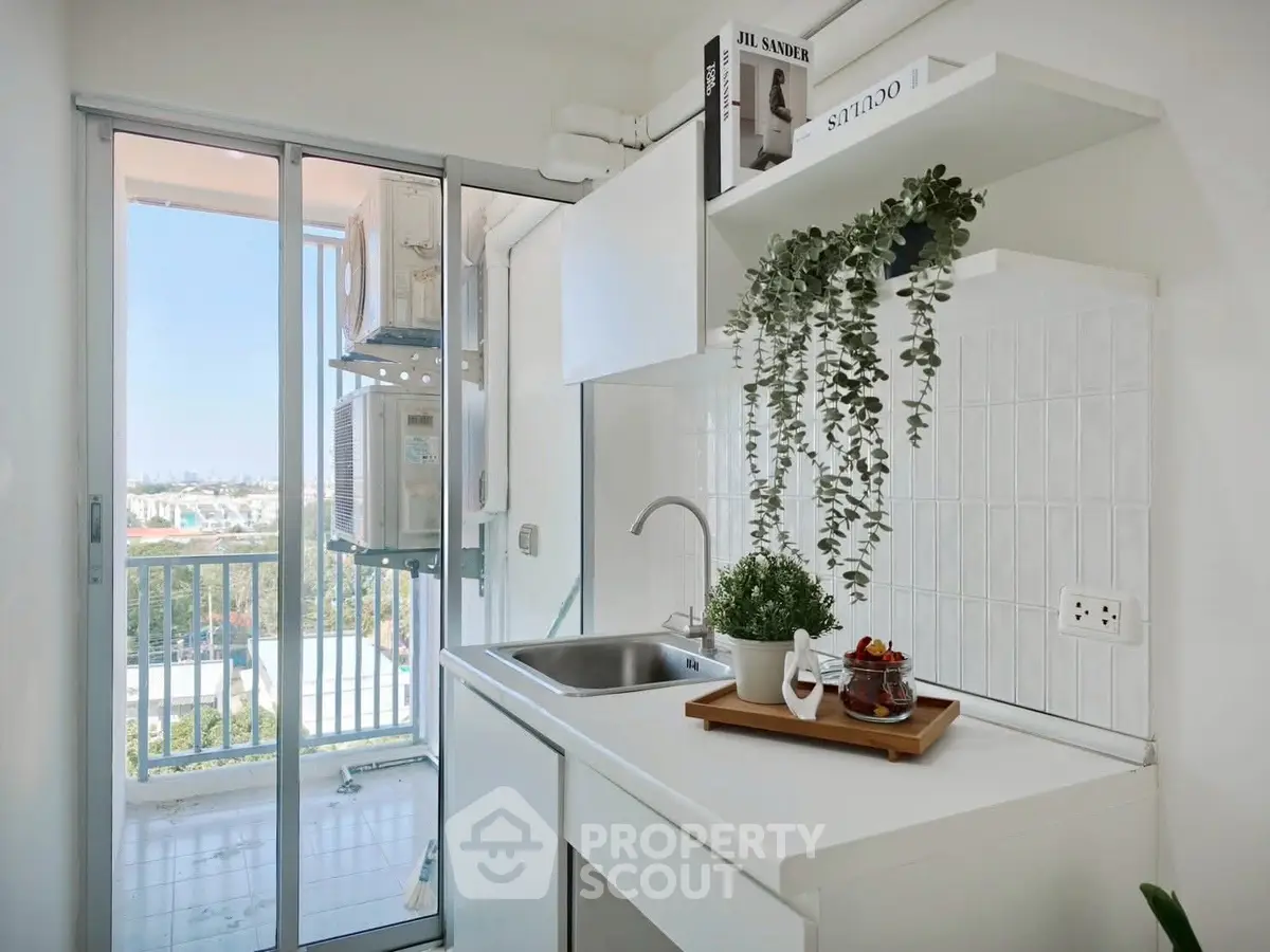 Modern kitchen with balcony view and sleek white cabinetry