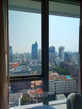 Stunning cityscape view from high-rise apartment window, showcasing urban skyline and modern architecture.