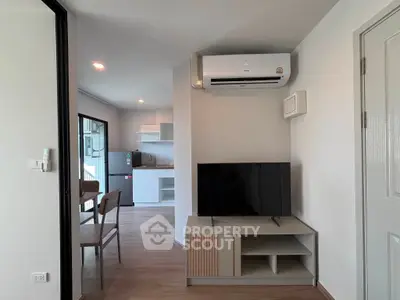 Modern living room with air conditioning and open kitchen layout in a stylish apartment.