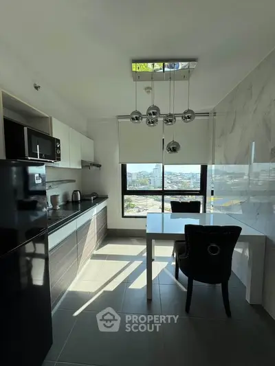 Modern kitchen with sleek cabinetry, large window view, and stylish dining area.