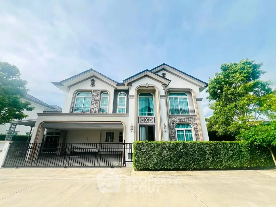 Elegant two-story house with manicured hedges and spacious driveway in a serene neighborhood.