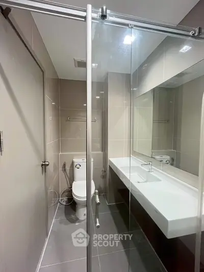 Modern bathroom with glass shower, sleek fixtures, and neutral tiles for a contemporary look.