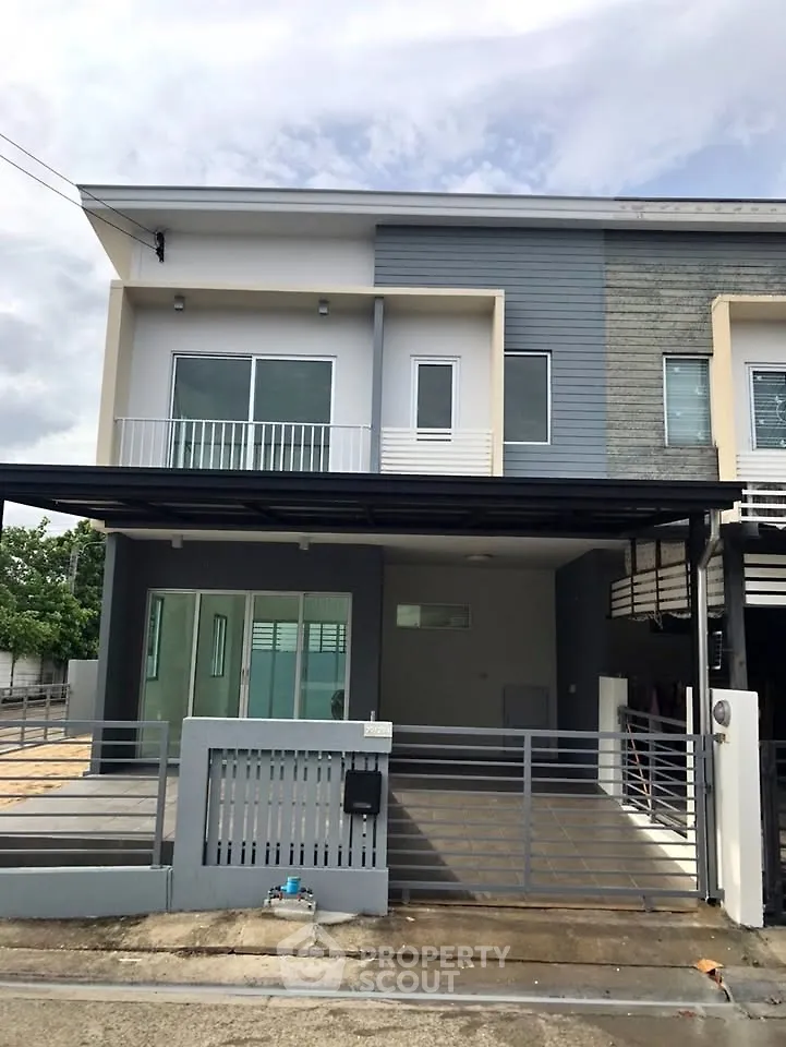 Modern townhouse exterior with sleek design and spacious driveway in a suburban neighborhood.