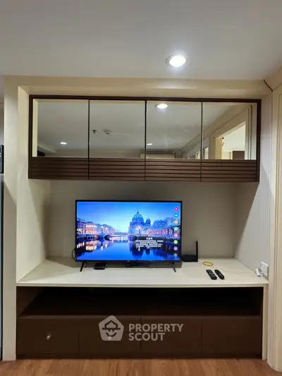 Modern living room with sleek TV unit and mirrored cabinets