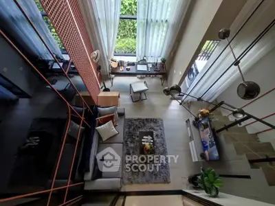 Stunning modern living room with high ceilings and large windows offering lush garden views.