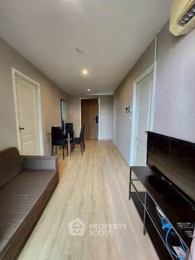 Modern living room with sleek furniture and wooden flooring in a stylish apartment.