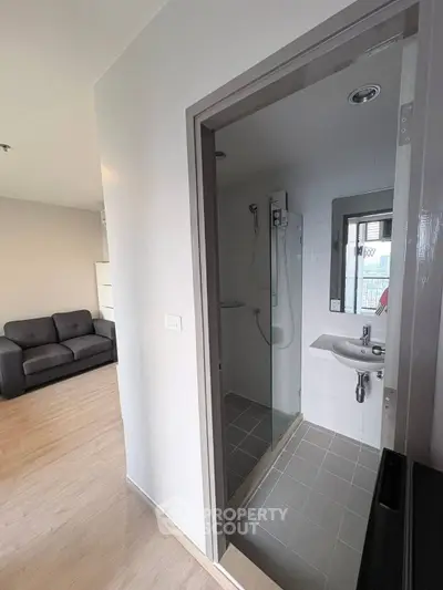 Modern apartment with cozy living room and compact bathroom featuring sleek design.