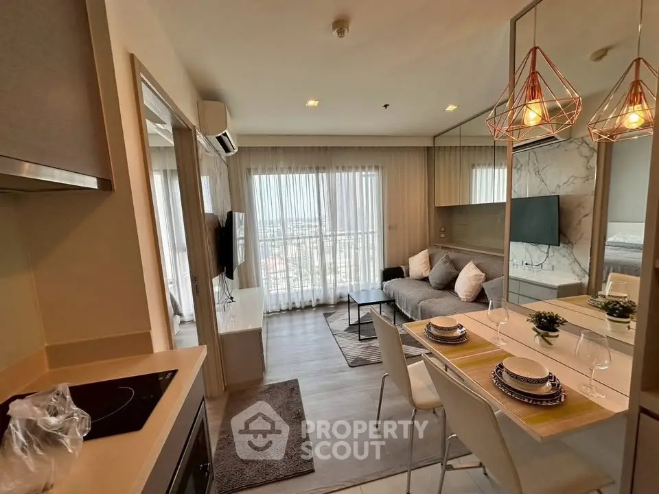 Modern open-layout living room with kitchen, featuring stylish decor and large windows offering city views.