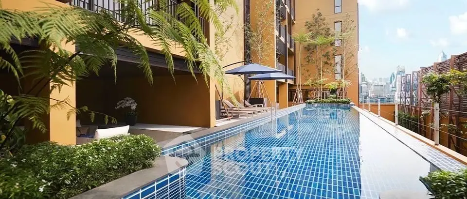 Luxurious rooftop pool with city skyline view in modern apartment complex.