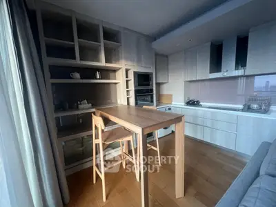 Modern kitchen with wooden cabinetry and dining area in a cozy apartment