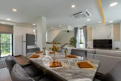 Luxurious open-plan living and dining area with modern decor and large windows.