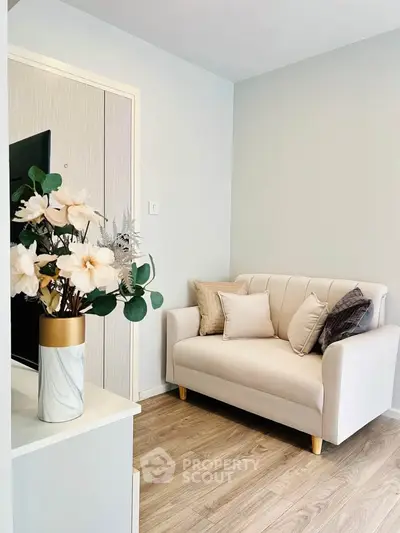 Cozy living room with elegant sofa and floral decor in modern apartment.