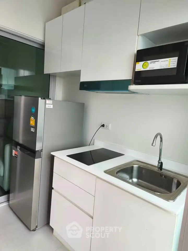 Modern kitchen with sleek appliances and minimalist design in a contemporary apartment.