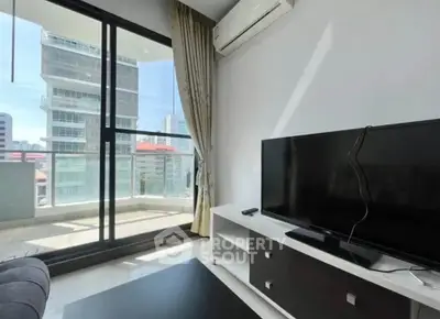 Modern living room with large TV and balcony view in urban apartment