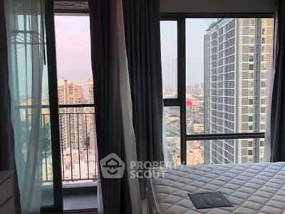 Modern bedroom with city view and balcony access in high-rise apartment