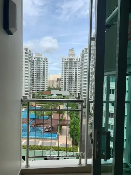 Stunning high-rise apartment view with pool and modern architecture.