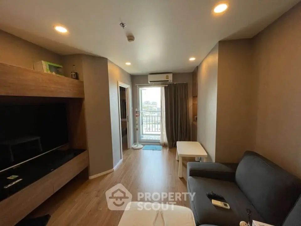 Modern living room with balcony access and stylish furnishings in a cozy apartment.