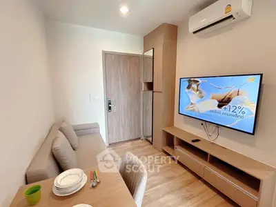 Modern living room with cozy sofa, wall-mounted TV, and dining area in stylish apartment.