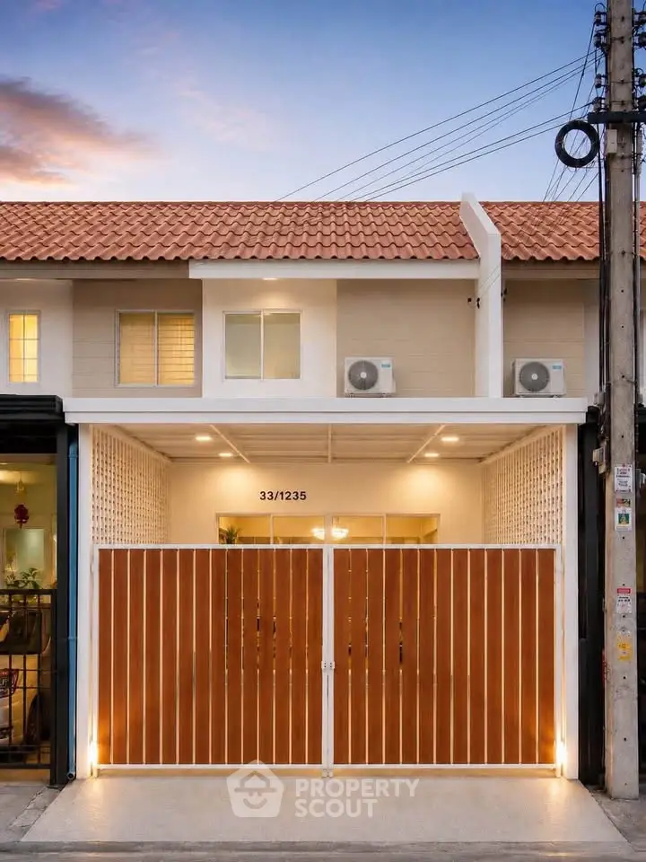 Charming townhouse with modern facade and warm lighting, perfect for cozy living.