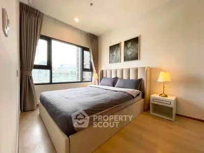Modern bedroom with large windows and stylish decor in a high-rise apartment.