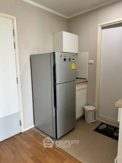 Modern kitchen corner with sleek fridge and wooden flooring