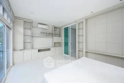 Spacious modern bedroom with built-in storage and large windows