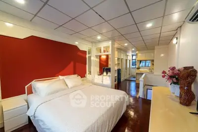 Spacious bedroom with modern design and vibrant red accent wall