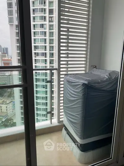 Modern high-rise balcony with city view and covered appliance