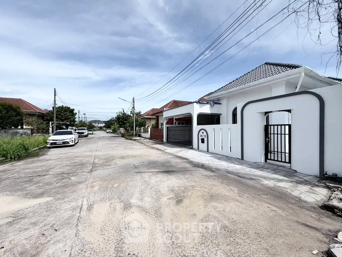 Charming suburban street with modern white house and gated entrance, perfect for family living.