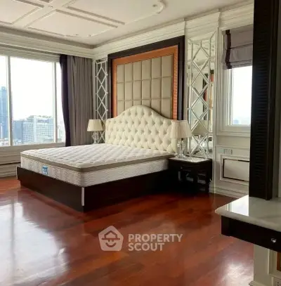Luxurious bedroom with elegant decor and city view, featuring a plush bed and hardwood floors.