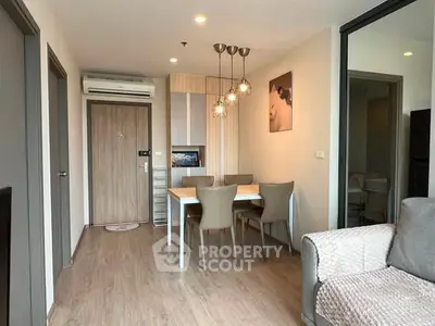 Modern living room with dining area, stylish lighting, and cozy seating in a contemporary apartment.