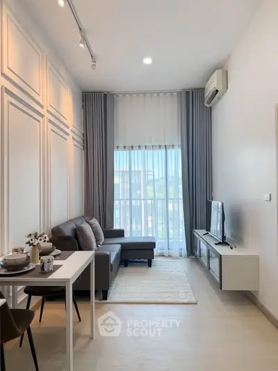 Modern living room with stylish decor, cozy sofa, and natural light from large window.