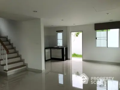 Spacious modern interior with sleek kitchen and staircase, perfect for contemporary living.