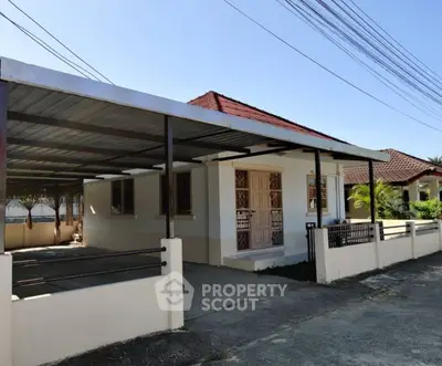 Charming single-story house with carport and tiled roof in a peaceful neighborhood.