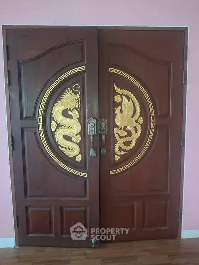 Elegant wooden double doors with intricate gold dragon carvings, perfect for a luxurious entrance.
