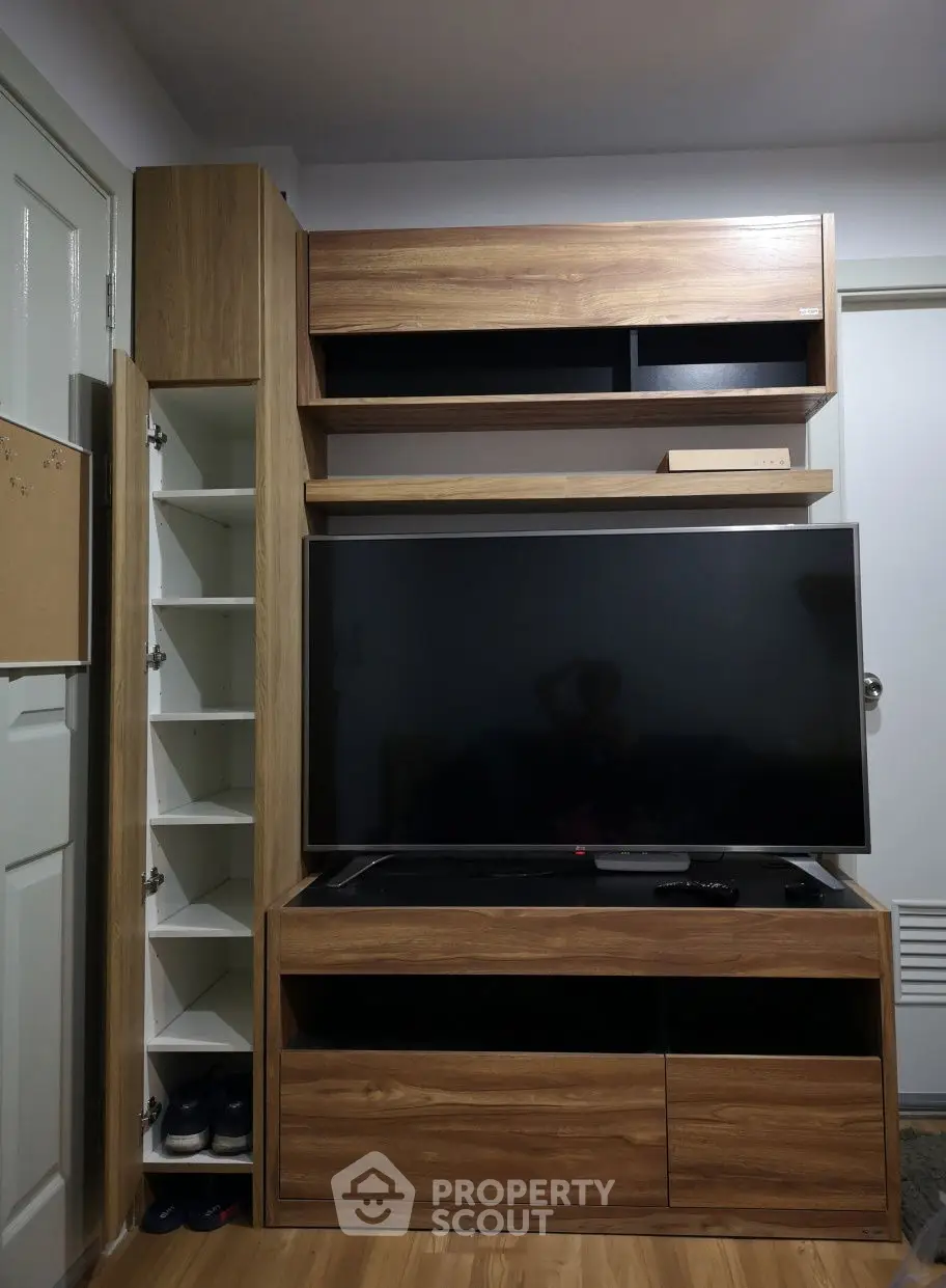 Modern living room with sleek wooden TV cabinet and ample storage space.