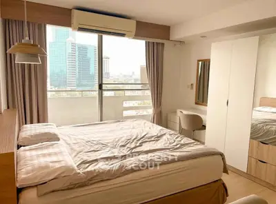 Modern bedroom with city view, featuring large windows and stylish furnishings.